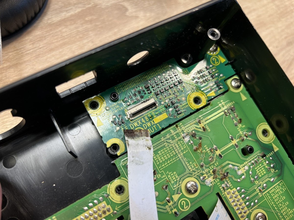 Uszkodzenia spowodowane zalaniem kontrolera DJ, widoczna skorodowana taśma.
