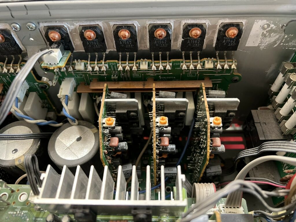 Końcówka mocy amplitunera Onkyo, widoczne tranzystory końcowe zamontowane do radiatora.